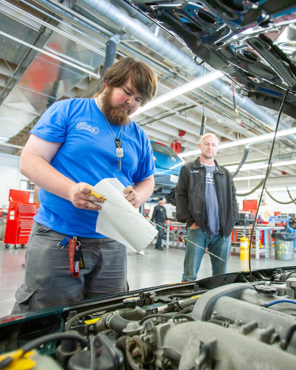 Student looking at car engine